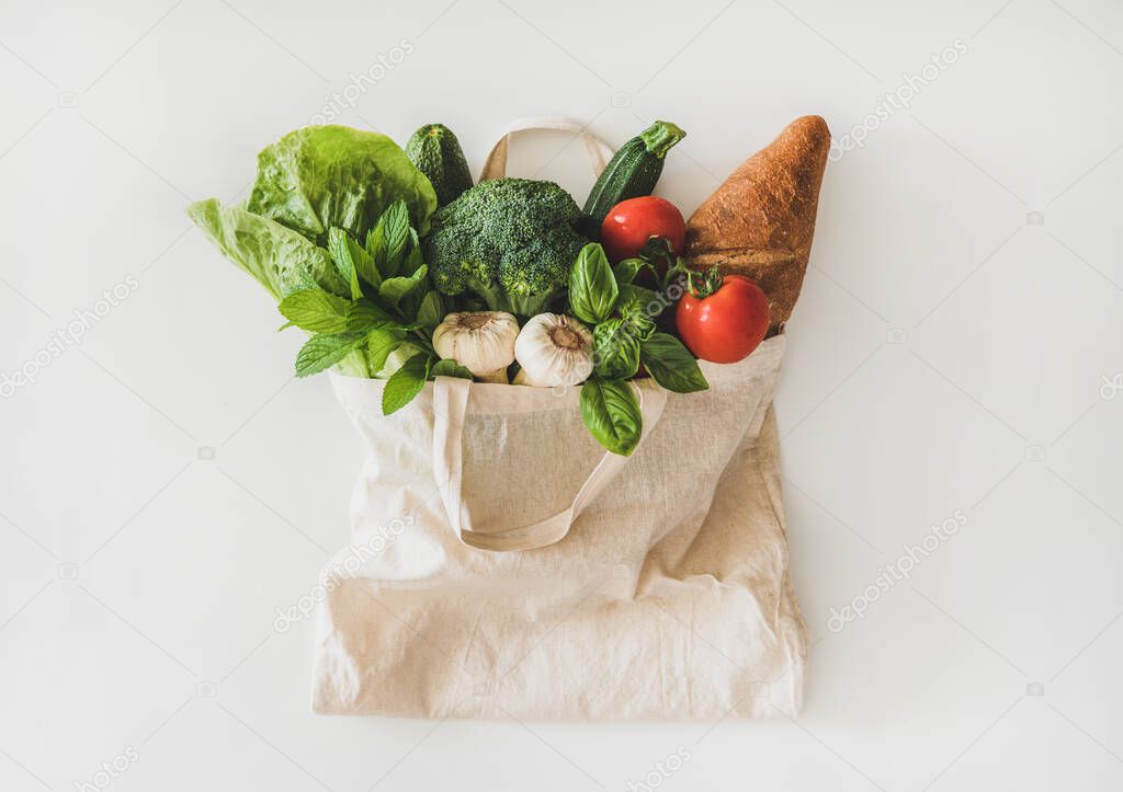Online grocery healthy shopping. Flat-lay of fruit, vegetables, greens and bread in eco-friendly bag over white background, top view. Shop online during pandemic of coronavirus banner for website