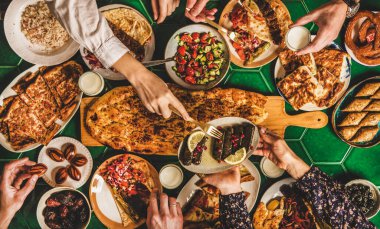 Müslüman Ramazan iftar aile yemeği. Orta Doğu yemekleriyle ziyafet çeken bir sürü insan. Hurma, dolma, kebap, düz ekmek, pide, borek, tatlı, salata, güzel manzara. Ramazan oruç tutan Türk mutfağı