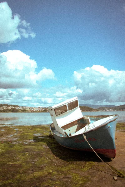 Un bateau dans le sable de la plage par une belle journée — Photo