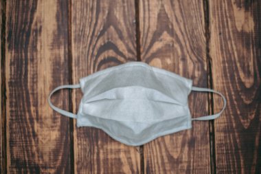 Tahta bir surfac üzerinde beyaz tıbbi maske var.