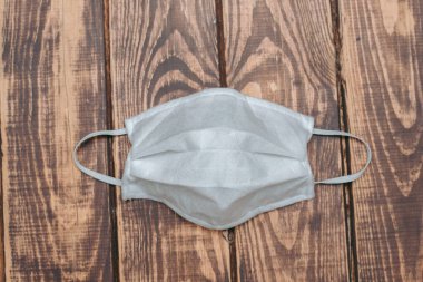 Tahta bir surfac üzerinde beyaz tıbbi maske var.