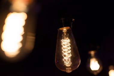 Edison lambası, siyah arka planda hafifçe sallanıyor.