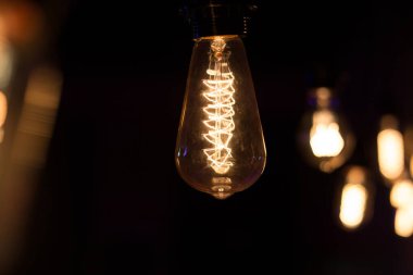 Edison lambası, siyah arka planda hafifçe sallanıyor.