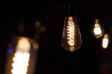 Edison lambası, siyah arka planda hafifçe sallanıyor.