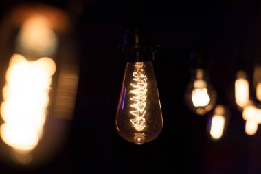 Edison lambası, siyah arka planda hafifçe sallanıyor.