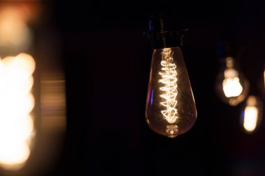 Edison lambası, siyah arka planda hafifçe sallanıyor.