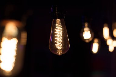 Edison lambası, siyah arka planda hafifçe sallanıyor.