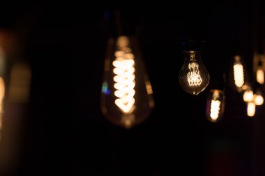 Edison lambası, siyah arka planda hafifçe sallanıyor.
