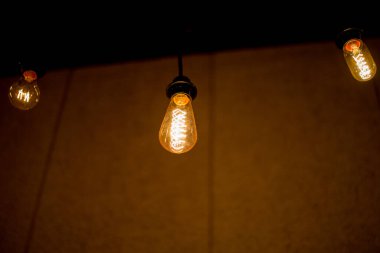 Edison lambası, siyah arka planda hafifçe sallanıyor.