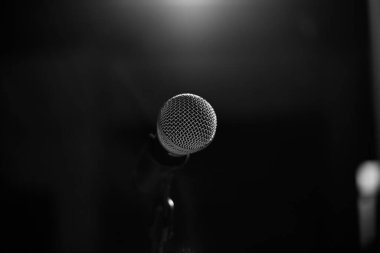 Sahne için mikrofon siyah bir arkaplanda duruyor. Siyah ve tel fotoğrafçılık.