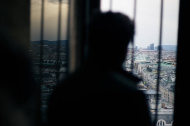 Gözlem güvertesinden bir adam pencereden dışarı bakıyor.