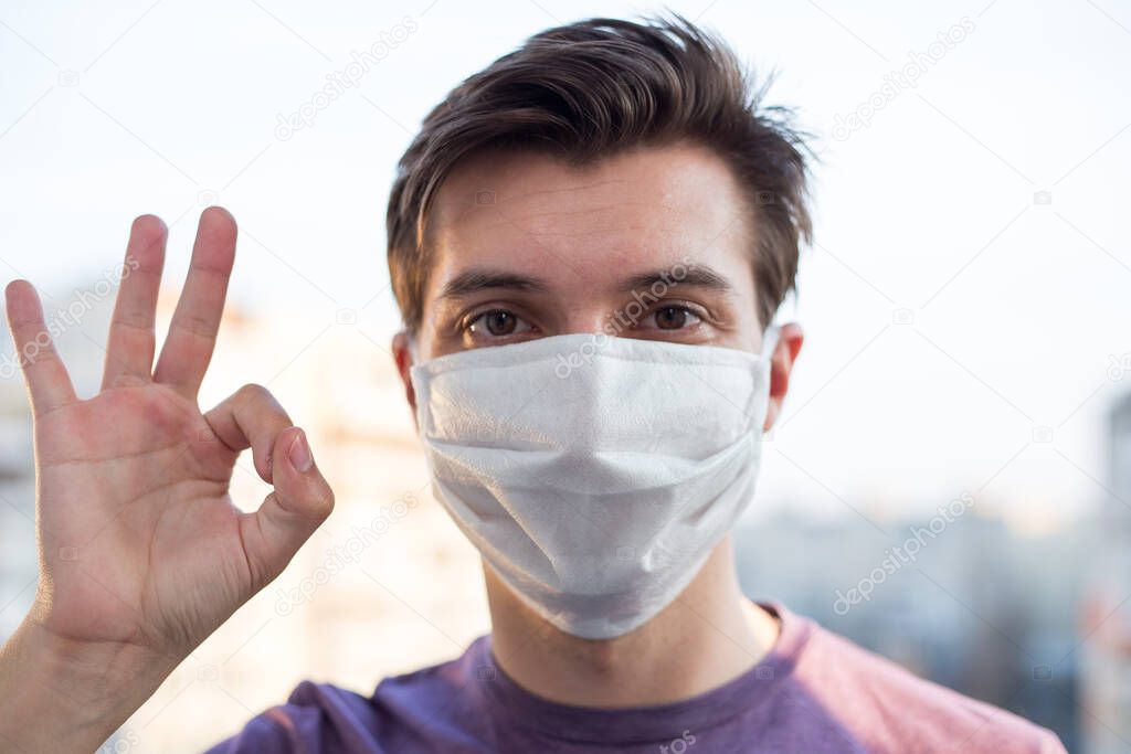 A young guy of European looking wears a medecine mask
