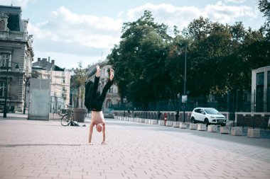 Şehir merkezinde çıplak gövde amuda kalkmış kel yaşlı bir adam.