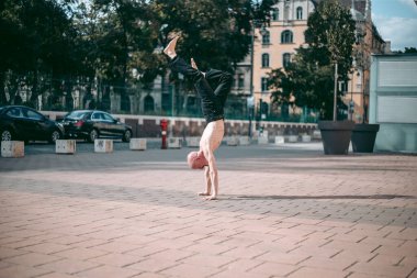Şehir merkezinde çıplak gövde amuda kalkmış kel yaşlı bir adam.
