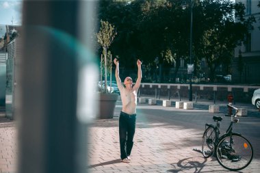 Şehir merkezinde çıplak gövde amuda kalkmış kel yaşlı bir adam.