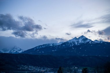 Karlı tepeli dağlarda. Eski Avrupa evleri. Bulutlu mavi gökyüzü.