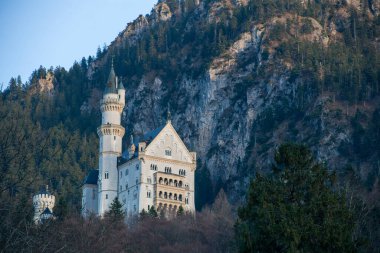 Kayalar, dağlar ve ormanlarla çevrili eski taş kale Neuschwanstein Kalesi