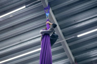 Spor salonunda hava jimnastiği yapan genç bir kız.