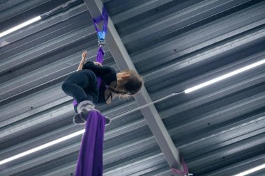 Spor salonunda hava jimnastiği yapan genç bir kız.