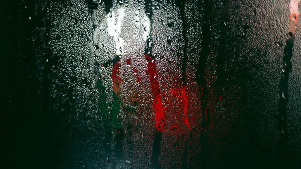 Wet foggy window on a background of lights