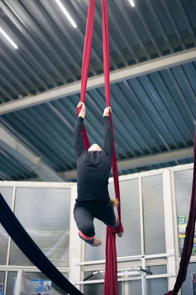 Young girl doing aerial gymnastics in the gym