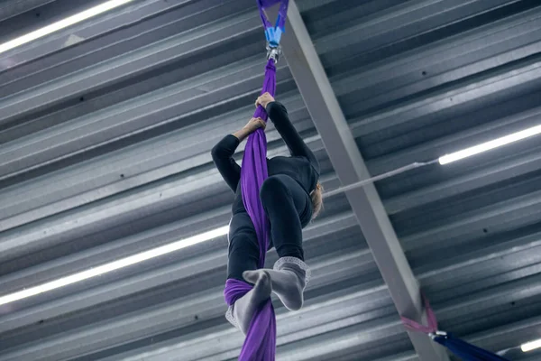 Young girl doing aerial gymnastics in the gym