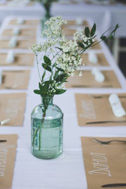 Beyaz masa örtüsü ile süslenmiş güzel bir düğün masası.