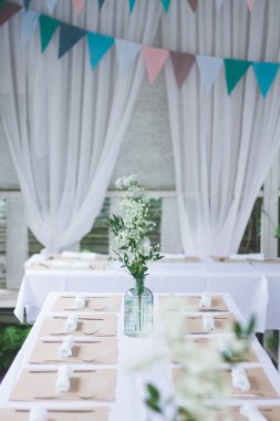 Beyaz masa örtüsü ile süslenmiş güzel bir düğün masası.