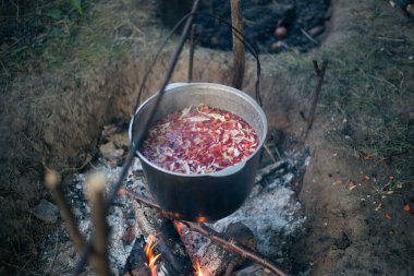 Kamp ateşinde çorba içen bir kazan.