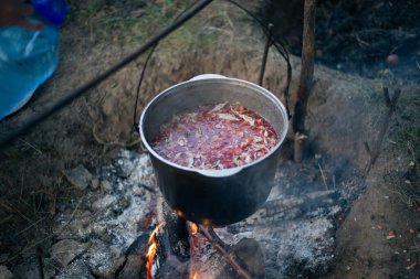 Kamp ateşinde çorba içen bir kazan.