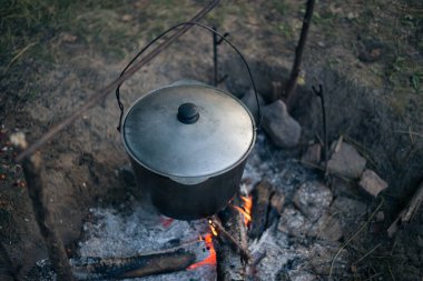 Kamp ateşinde çorba içen bir kazan.