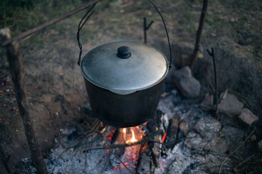 Kamp ateşinde çorba içen bir kazan.