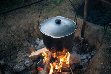 Kamp ateşinde çorba içen bir kazan.