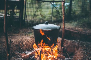 Kamp ateşinde çorba içen bir kazan.