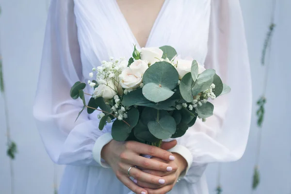 Beautiful wedding bouquet in the hands of the bride