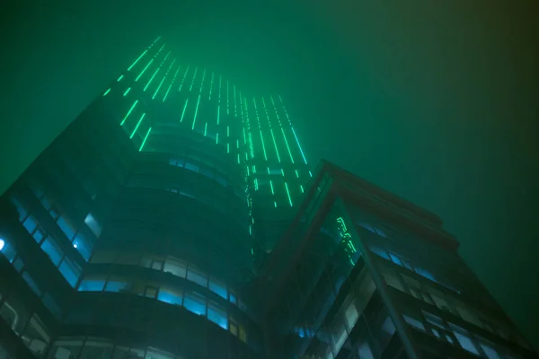 霧の中で夜の高層オフィスビル — ストック写真