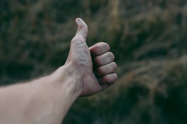 Koyu kahverengi arka planı olan bir insan eli.