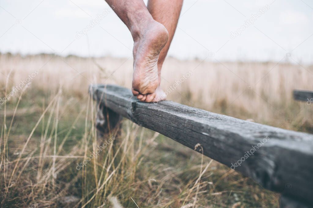 Man barefoot on the log in daylight