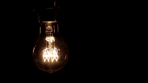 Close Edison Lamp Warm Light Sways Lightly Black Background — Stock Video