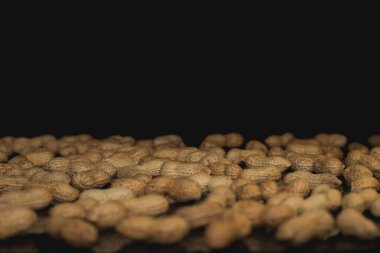 Kabuk ve arka planda kızarmamış fıstıklar.