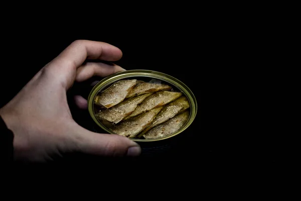 Canned fish sprats in a jar and black background
