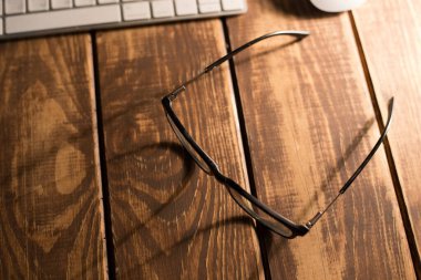 Gözlük, görüş düzeltme ve ahşap masadaki bilgisayardan koruma.