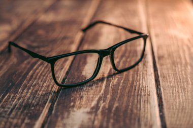 Gözlük, görüş düzeltme ve ahşap masadaki bilgisayardan koruma.