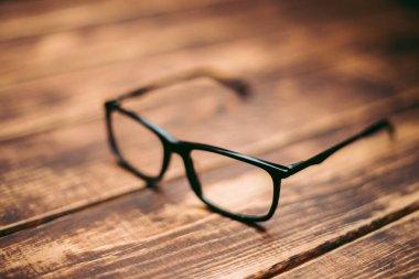 Gözlük, görüş düzeltme ve ahşap masadaki bilgisayardan koruma.
