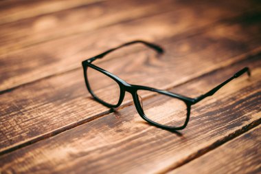 Gözlük, görüş düzeltme ve ahşap masadaki bilgisayardan koruma.