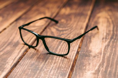 Gözlük, görüş düzeltme ve ahşap masadaki bilgisayardan koruma.