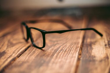 Gözlük, görüş düzeltme ve ahşap masadaki bilgisayardan koruma.