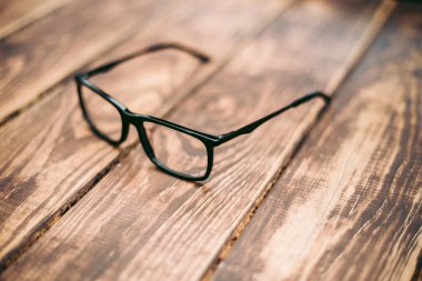 Gözlük, görüş düzeltme ve ahşap masadaki bilgisayardan koruma.