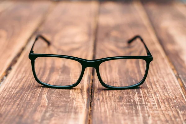 视力和视力矫正用眼镜和木制桌子上的计算机保护 — 图库照片