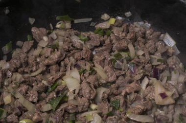 Tavada pişmiş sığır eti, soğan ve yeşil biber.